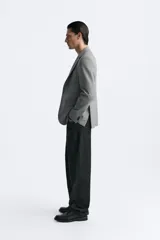 Blazer straight fit color gris claro confeccionado en tejido con viscosa. Tiene cuello con solapas de muesca, manga larga acabada en puño con botón, bolsillo de vivo en pecho, bolsillos de plastrón en cadera y bajo con aberturas en espalda. Cierre frontal de botonadura.