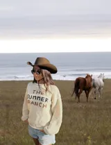 Sweater tejido a mano en lana merino virgen sin teñir, con letras bordadas a mano en tono azul marino y chocolate. Diseño unisex y calce relajado.