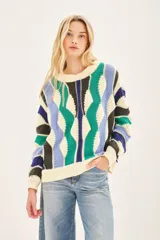 Sweater de punto con tejido desagujado y recortes asimétricos. Detalles de rib en escote, mangas y cuello.