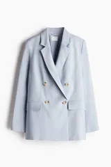Blazer celeste de doble botonadura con solapas de muesca, hombreras y bolsillos delanteros ribeteados con solapa.