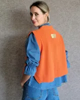 Chaleco de punto marrón con cuello redondo y sisas amplias.