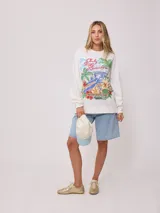 Sweater color crema con estampado frontal de motivos playeros y bordado. Confeccionado en 60% algodón y 40% poliéster.