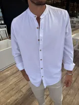 Camisa blanca de lino con cuello mao, manga larga y corte recto.