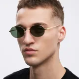 Lentes de sol ovalados con montura dorada y lentes verdes polarizadas.