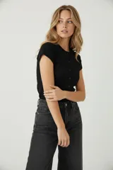 Saco de algodón y elastano, color negro, de corte al cuerpo, con cuello redondo y botones frontales.