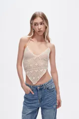 Top tejido al crochet color crema, con cuello halter y espalda descubierta.
