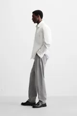 Pantalón de jean gris de corte recto, con cinco bolsillos, efecto lavado y cierre frontal con botones.