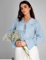 Short celeste de gabardina de algodón, tiro alto, corte amplio, pinzas frontales, bolsillos laterales, cierre y botón metálico.