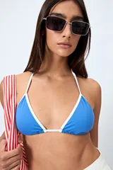 Top de bikini triangular negro con bordes blancos y tirantes finos.
