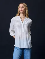 Blusa blanca de gasa bambula, marca Zac & Rachel. Cuello a la base, escote en V con apertura y botones. Largo de manga regulable con presilla y botón.