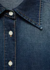 Camisa de denim azul con cuello camisero, cierre de botones, mangas largas y corte oversize.