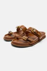 Sandalias planas negras con dos tiras anchas y hebillas doradas.