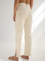 Pantalón negro de gabardina con alforzas verticales en los laterales y aberturas en el ruedo.