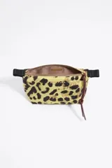 Neceser trapecio de nylon con estampado animal print en color amarillo, con cierre de cremallera y tirador de piel regenerada.