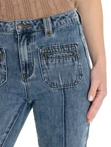 Pantalón de jean azul de tiro alto, corte bootcut y bolsillos delanteros con costuras decorativas.