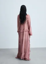 Vestido largo color rosa viejo, de tela traslúcida con volados y mangas largas abullonadas.