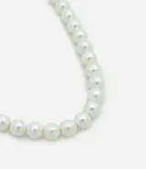 Collar corto de perlas blancas con cierre metálico dorado.