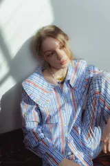 Camisa de manga larga con mega cuello bobo en tonos azules, rojos y naranja.