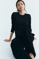 Remera entallada de manga larga, color negro, con escote redondo ribeteado.