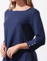 Blusa en tejido acanalado, marca Ruby Rd. Largo de mangas ¾ con abertura y botones. Terminación de ruedo asimétrico.