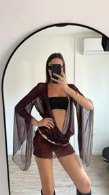 Vestido corto marrón traslúcido con escote en V profundo, mangas largas acampanadas y cinturón dorado.