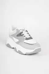 Zapatillas blancas con recortes en diferentes tonos de gris, cordones y plataforma irregular de 5cm.