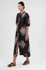 Vestido camisero midi de algodón y lino color gris con estampado de tigresas y flores en tonos azules y naranjas. Tiene cuello mao, mangas abullonadas cortas y cierre frontal con botones.