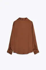 Camisa color marrón satinado, de corte holgado, con cuello solapa, escote en pico, manga larga y cierre frontal con botones.