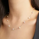 Collar plateado con cadena fina y dijes colgantes de perlas y strass.