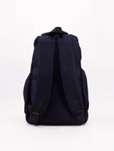 Mochila de tela color azul marino, con compartimento principal y bolsillo frontal con cierre. Presenta un asa superior y tirantes ajustables. En el lateral inferior izquierdo tiene una etiqueta negra con texto blanco.