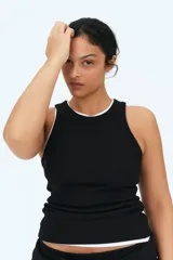 Musculosa negra de punto de algodón acanalado, corte entallado, cuello redondo y ribete fino en escote y sisas.