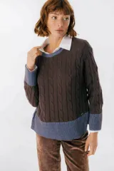 Sweater color camel con tejido de trenzas y terminaciones en color beige.
