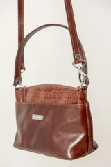 Cartera de cuero color marrón con diseño estructurado y cierre superior.