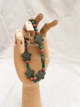 Collar de cuentas de colores con dijes de estrellas de piedra volcánica.