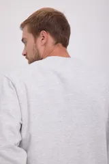 Buzo gris melange de manga larga y cuello redondo, con calce holgado y tejido de felpa suave en el interior.