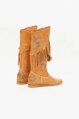 Bota alta color cuero con flecos, apliques de cuero con estampado reptil, tachas plateadas y costuras a la vista.