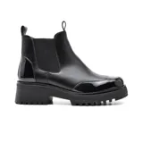 Bota Chelsea de cuero sintético negro con elástico lateral, puntera y talón charolados, plataforma track y tiradores en la caña.