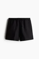 Short negro de corte holgado, con cintura elástica ajustable con cordón y bolsillos laterales.