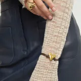 Pulsera ajustable con cordón de cuero marrón y un dije central de corazón dorado con textura martillada. Incluye un cierre de bola deslizante en la parte superior.