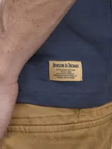 Remera azul marino de algodón con estampado en la espalda de un paisaje con un sol y montañas en tonos celeste, gris y blanco. Tiene la inscripción 'Benson & Thomas' en la parte superior.
