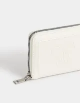 Billetera de cuerina color blanco crudo con cierre circundante y moño en relieve.