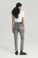 Jean momfit gris con lavado ácido y tachas en los costados a la altura de la cadera.