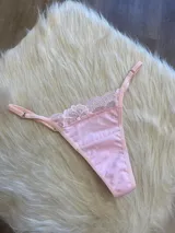 Tanga rosada de algodón con encaje en la parte delantera y tiras regulables.