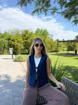 Chaleco azul denim con escote en V y cierre frontal con lazos.