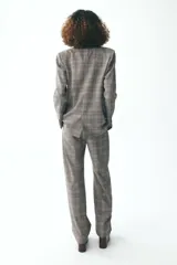 Blazer de Zara Woman Collection, con cuello solapa y manga larga. Tiene bolsillos delanteros y cierre cruzado con botones.