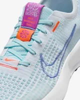 Championes de running Nike Interact Run para mujer, color celeste con detalles en violeta y naranja.