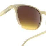 Lentes de sol Izipizi Sun E con montura color crema y lentes marrones degradé.