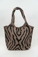 Bolso tipo tote con estampado animal print cebra en tonos marrón y negro.