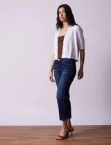Bolero tejido blanco de manga corta con apliques de botones en los puños.