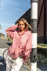 Camisa oversize de lino a rayas verticales color salmón y blanco, con bolsillo de parche en el pecho y botones al tono.